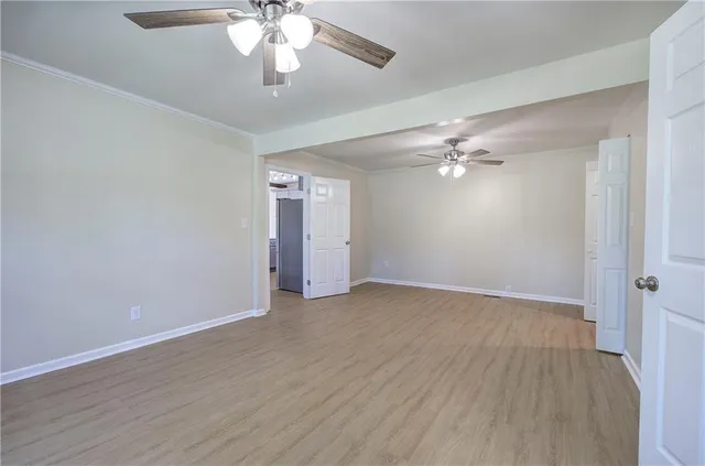 a view of an empty room with wooden floor