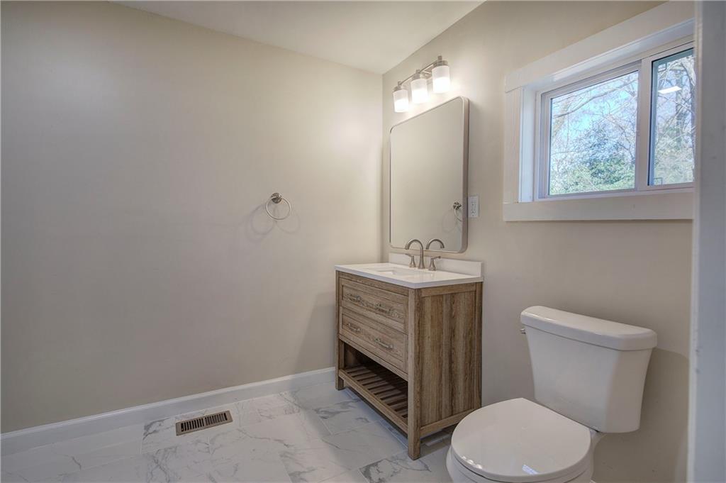 415 East 10th Street Rome, GA 30161 - Photo 30 of 42 a bathroom with a toilet a sink and mirror