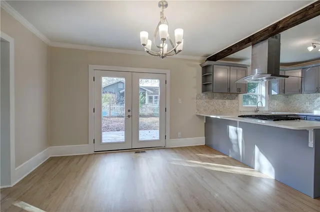 a view of a kitchen with granite countertop wooden floor and stainless steel appliances