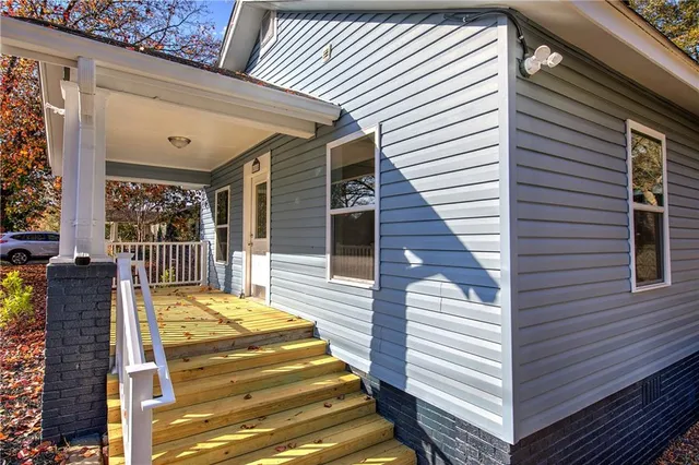 a view of a patio with two couches and deck with wooden floor and fence