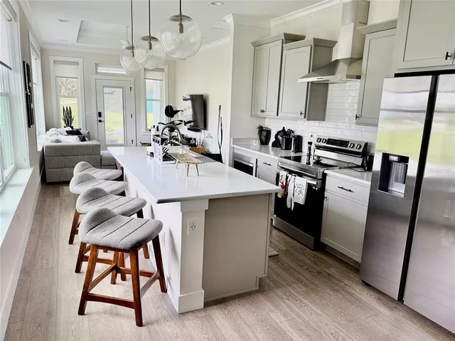 a kitchen with stainless steel appliances granite countertop a sink a stove and a refrigerator