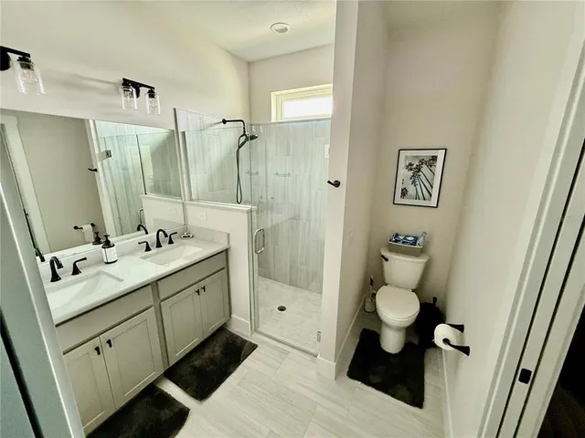 a bathroom with a double vanity sink mirror and toilet