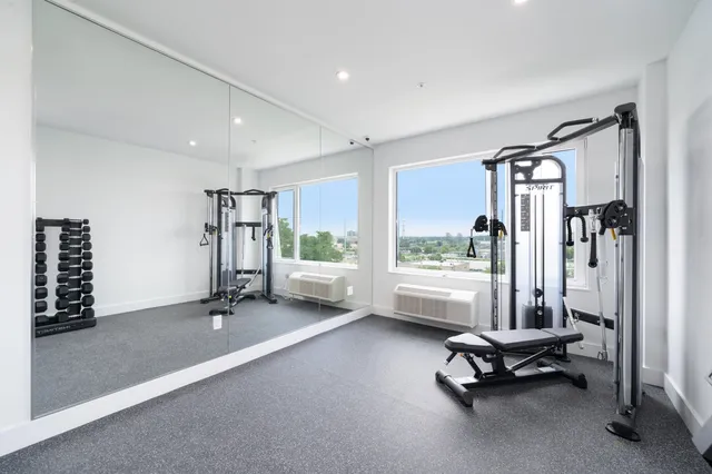 a view of a room with gym equipment and floor to ceiling window