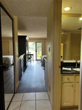 a hallway view with stainless steel appliances a sink and wooden floor
