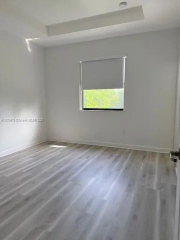 a view of empty room with window and wooden floor