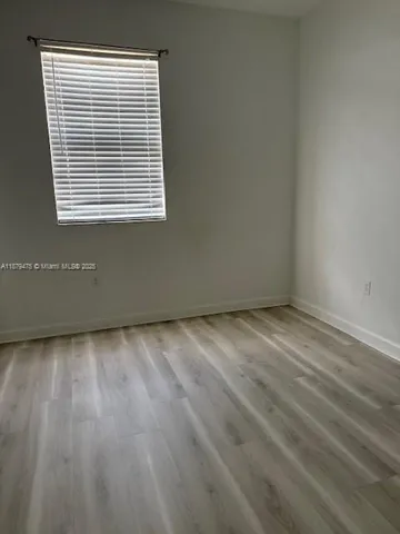a view of a room with wooden floor and a window