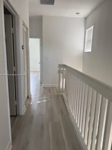 a view of a hallway with wooden floor