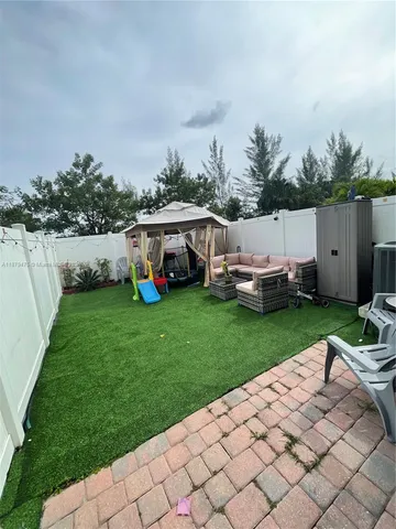a view of a house with backyard sitting area and garden