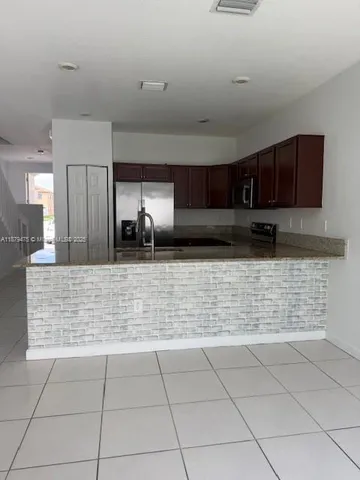 a view of kitchen with granite countertop cabinets