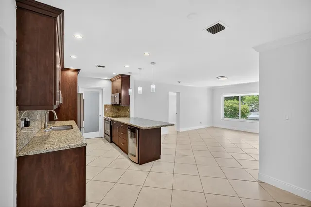 a large kitchen with stainless steel appliances granite countertop a refrigerator and a sink