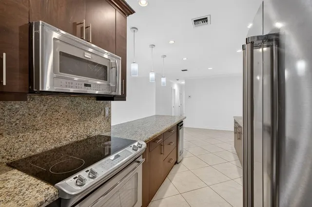 a bathroom with a granite countertop toilet sink and mirror