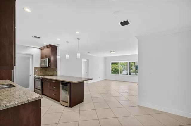 a view of a house with a big yard and palm trees