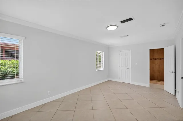 a backyard of a house with plants and large tree