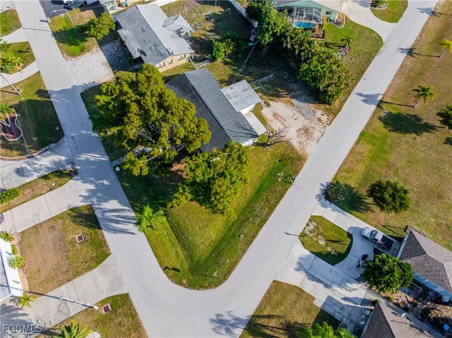 an aerial view of a house with a yard and large trees