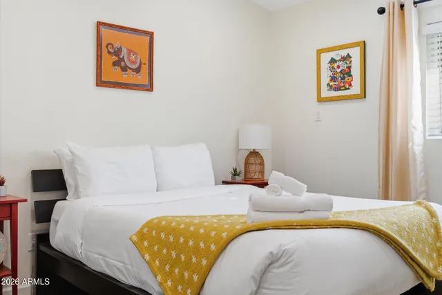 a bedroom with a bed and painting on the wall