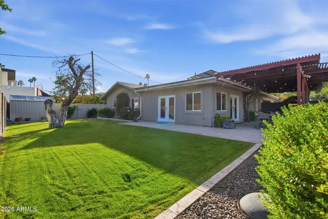 a view of a house with backyard and a tree