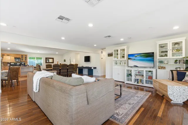 a living room with furniture a wooden floor and next to a window