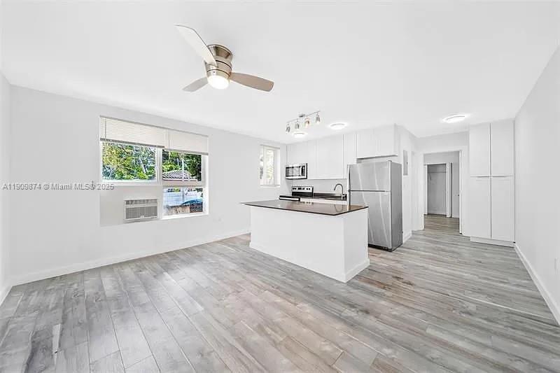 a view of kitchen with wooden floor and electronic appliances