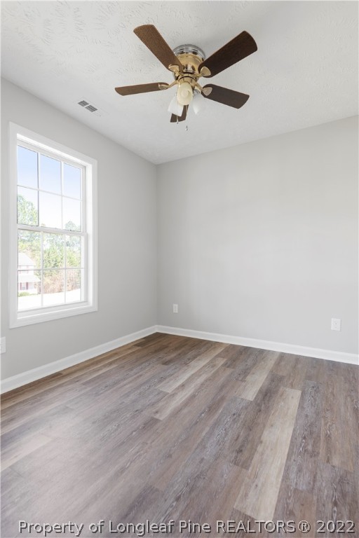 1150 Roundabout Road Cameron, NC 28326 - Photo 17 of 22 an empty room with wooden floor fan and windows