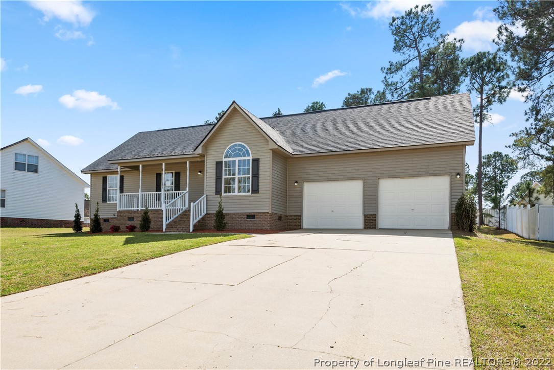 1150 Roundabout Road Cameron, NC 28326 - Photo 2 of 22 a front view of a house with a yard and garage