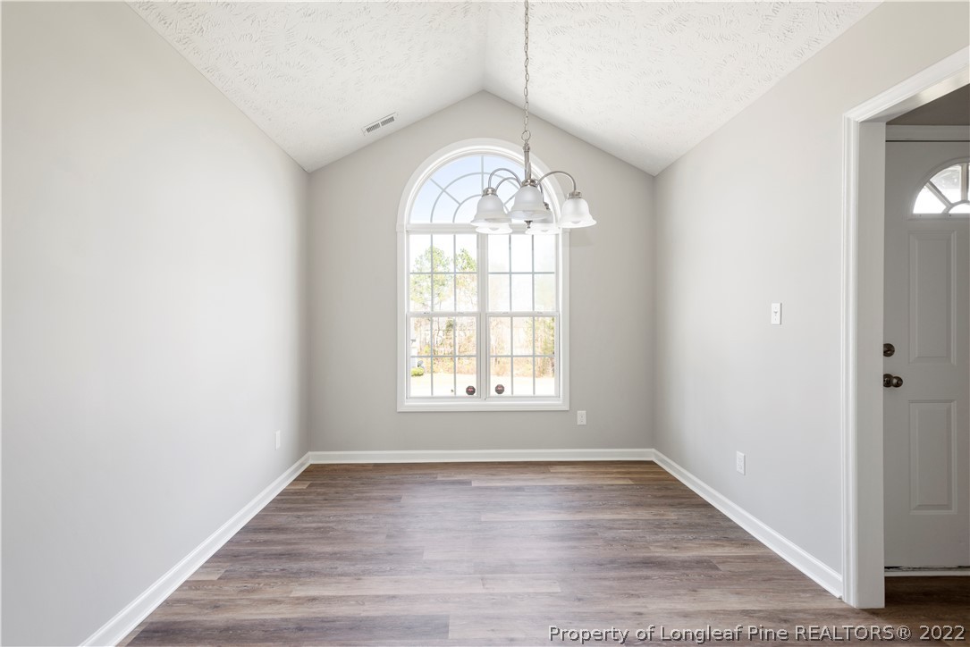 1150 Roundabout Road Cameron, NC 28326 - Photo 7 of 22 an empty room with wooden floor windows and entrance