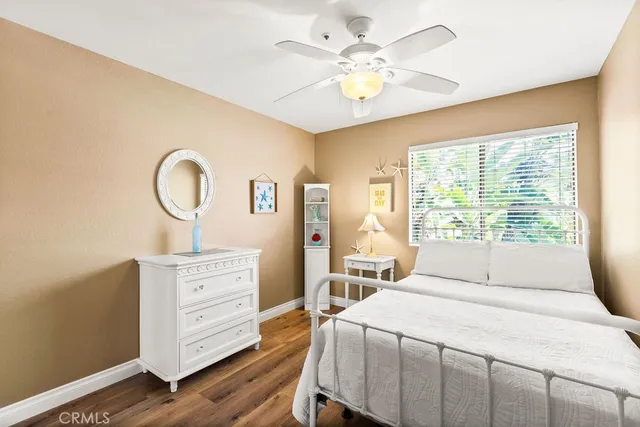a bedroom with a bed a chandelier and dresser