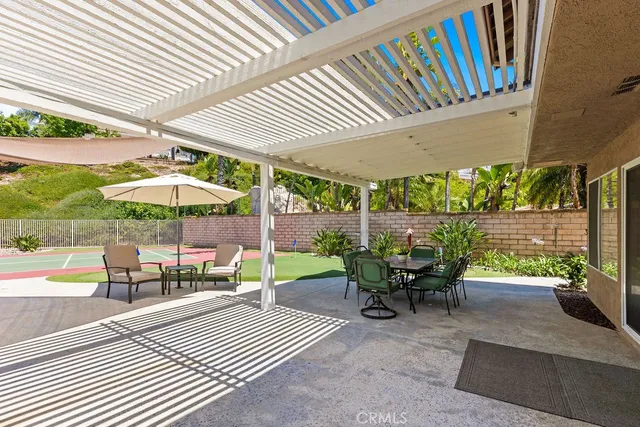 a view of a patio with a table and chairs under an umbrella