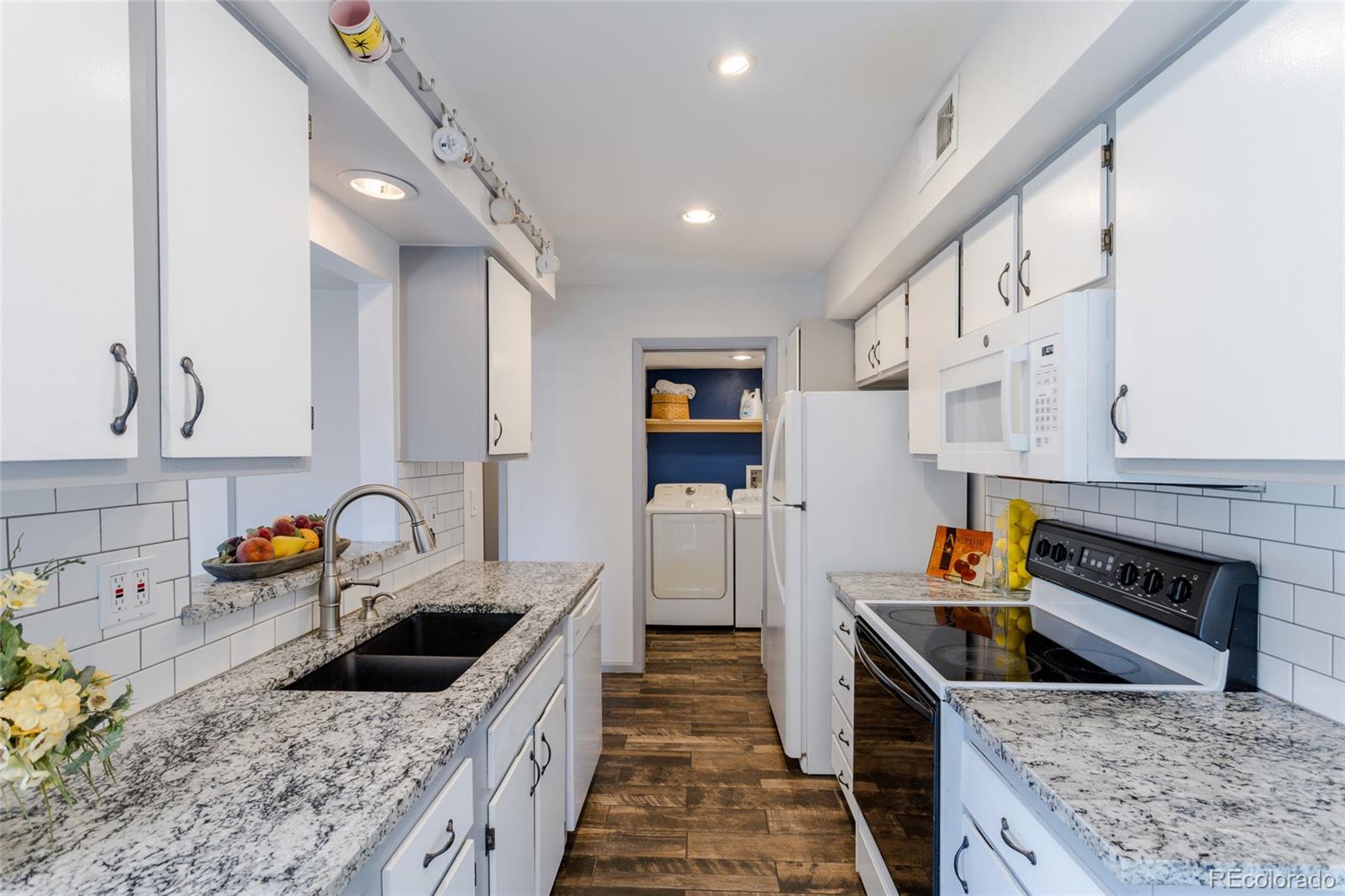 12143 Bannock Street, Unit B Denver, CO 80234 - Photo 13 of 32 a kitchen with stainless steel appliances granite countertop a sink stove and refrigerator