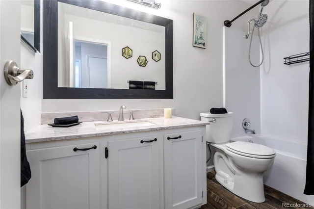 a bathroom with a granite countertop sink toilet and mirror