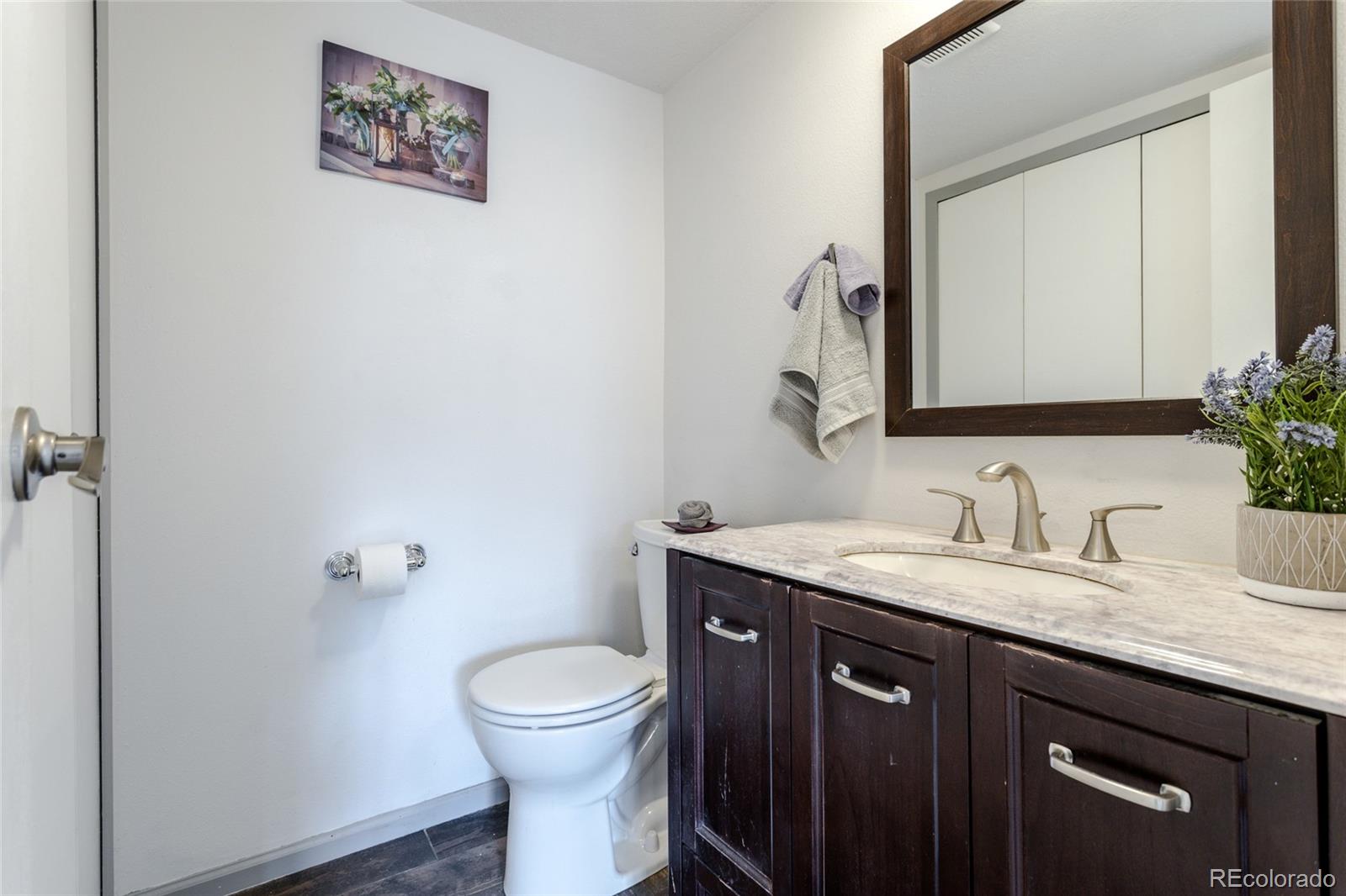12143 Bannock Street, Unit B Denver, CO 80234 - Photo 25 of 32 a bathroom with a granite countertop toilet sink and mirror
