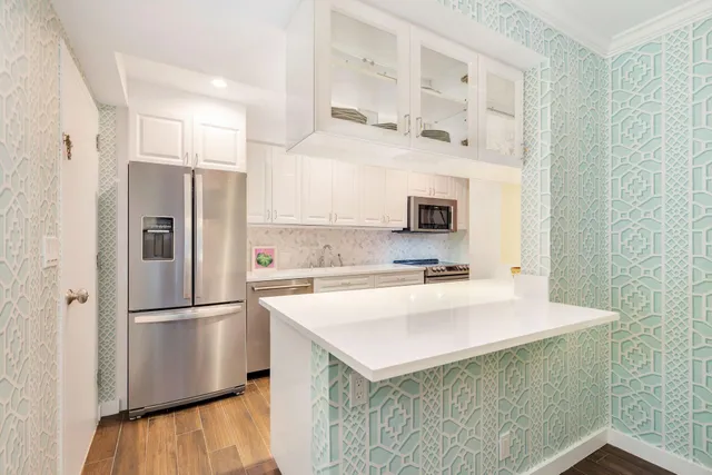 a kitchen with a refrigerator a sink and a stove top oven
