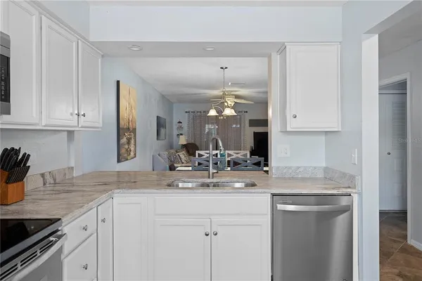 a kitchen with kitchen island granite countertop a sink cabinets and wooden floor