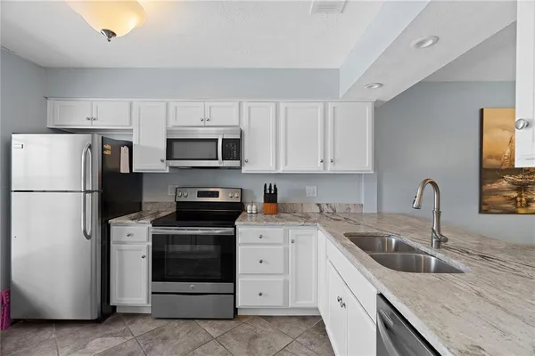a kitchen with white cabinets and stainless steel appliances