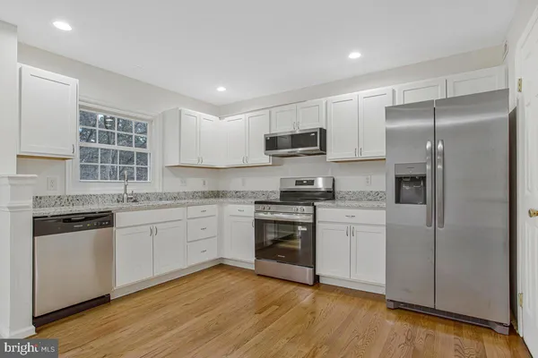 a kitchen with kitchen island granite countertop stainless steel appliances cabinets a sink and a counter top space