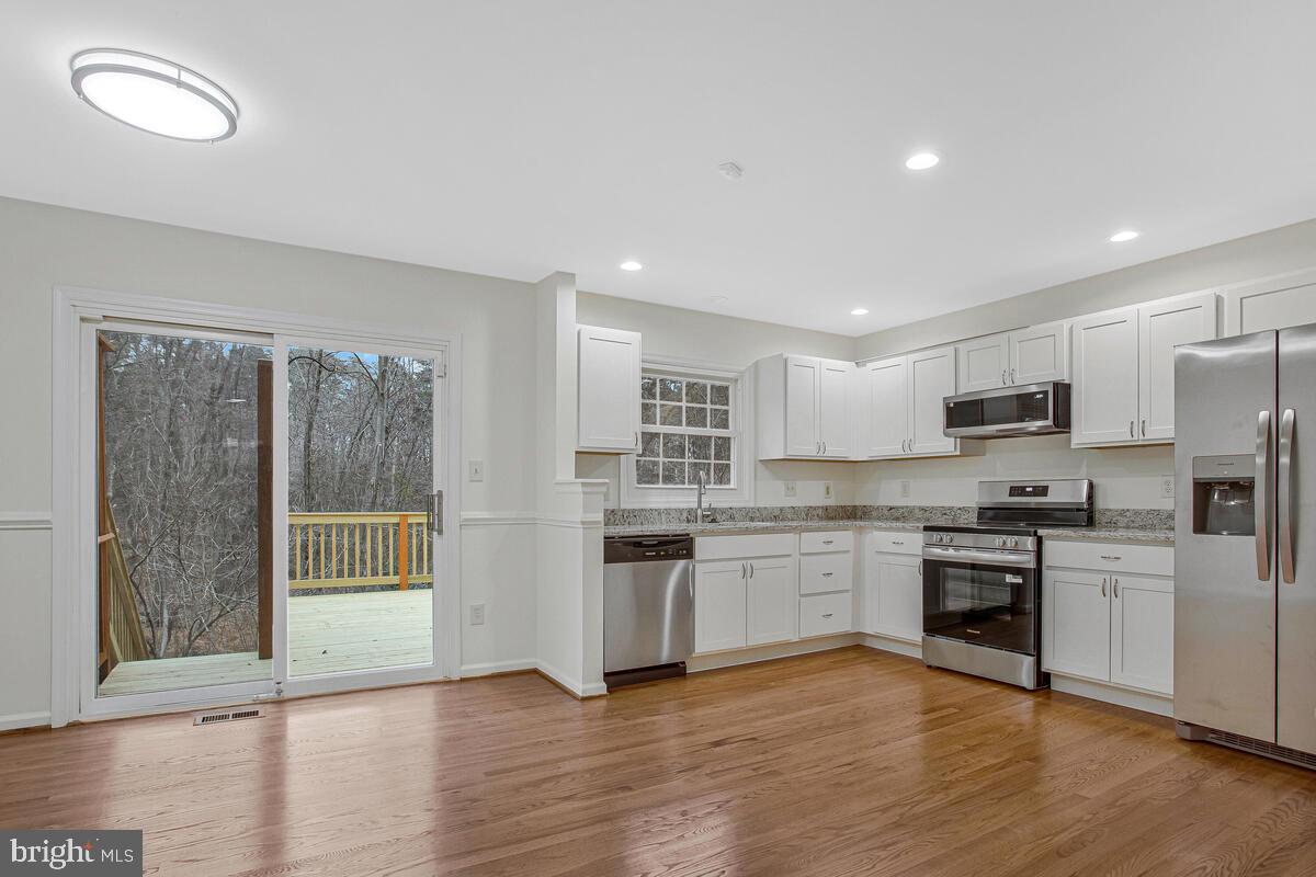 2144 Commissary Circle Odenton, MD 21113 - Photo 4 of 35 a kitchen with stainless steel appliances granite countertop a stove top oven a sink and a refrigerator