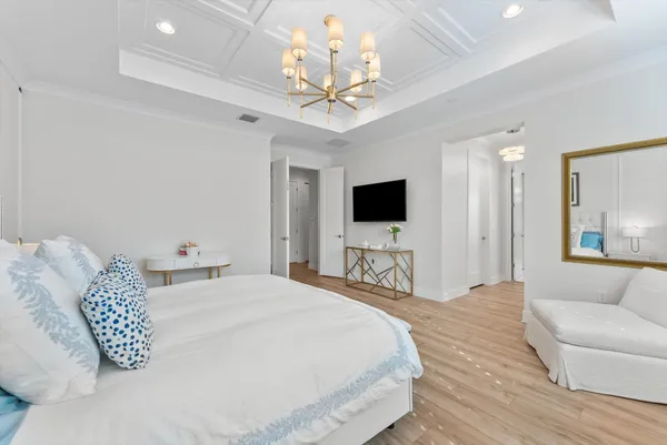 a bedroom with a large bed and a chandelier