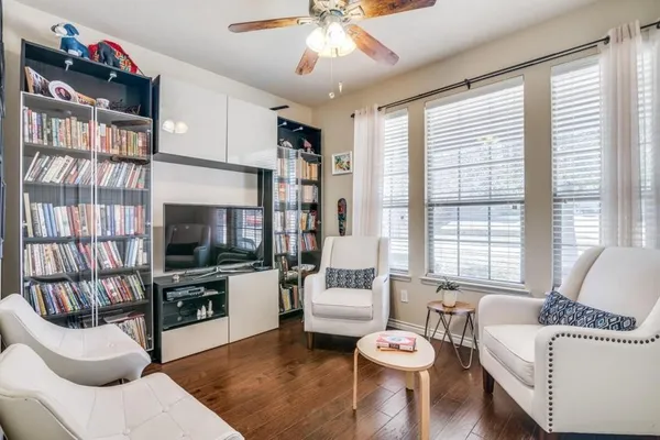 a living room with furniture a flat screen tv and a large window