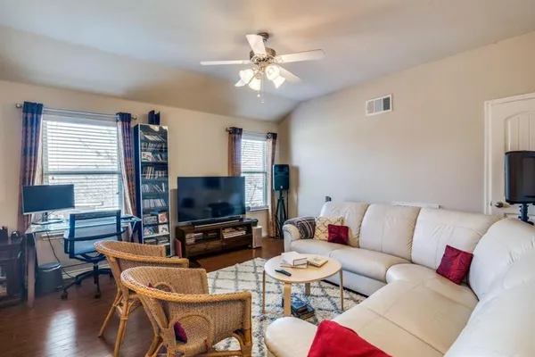 a living room with furniture a flat screen tv and a fireplace