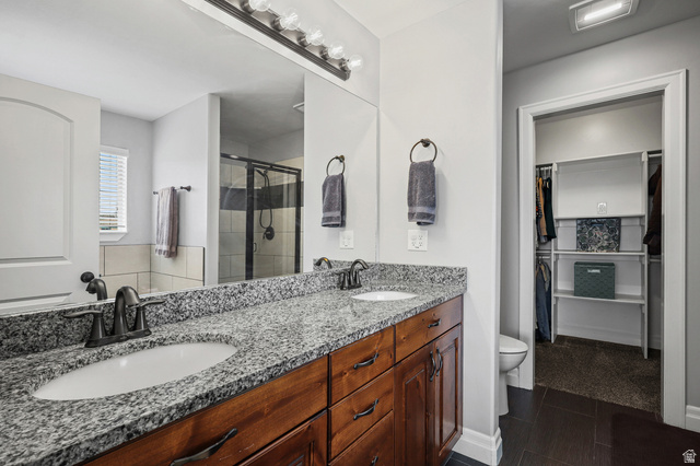1588 West Rim Rock Drive Stockton, UT 84071 - Photo 20 of 61 Dual vanity with granite countertops, undermount sinks, and dark wood-finish cabinetry