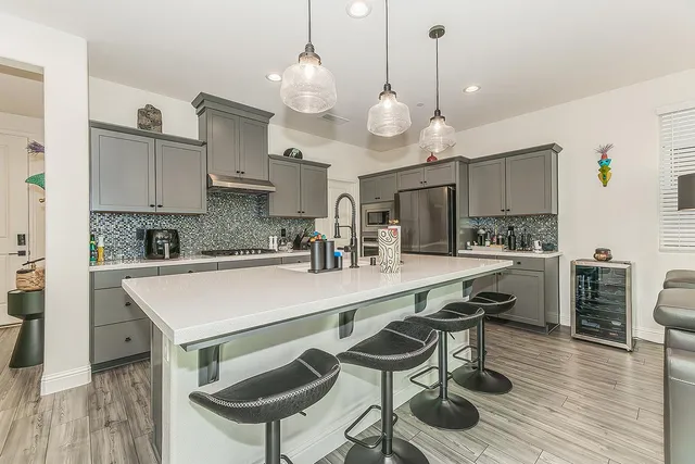a kitchen with sink a stove and chairs