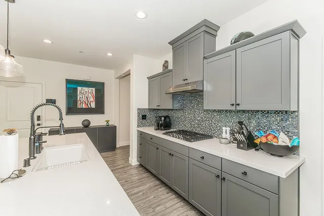 a kitchen with a sink a counter top space a stove and a window