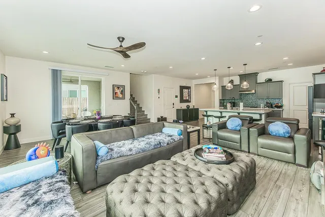 a living room with furniture kitchen view and a chandelier