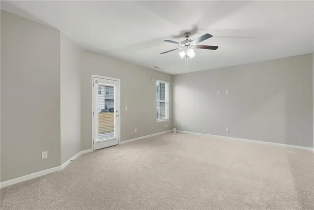 a view of an empty room with chandelier fan