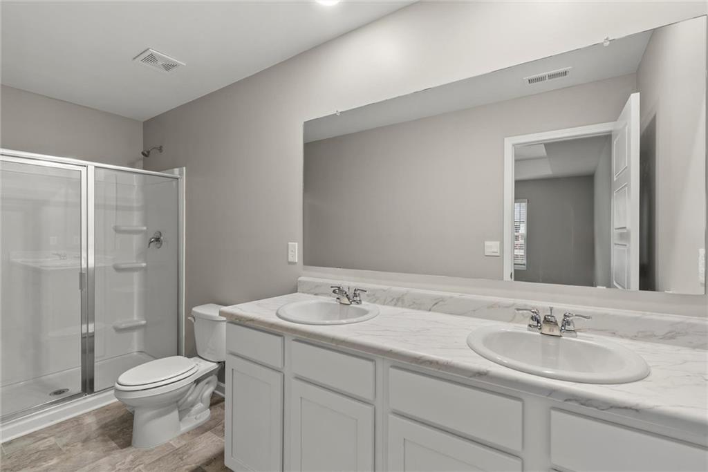 2650 Axel Ridge Decatur, GA 30034 - Photo 19 of 29 a bathroom with a toilet a sink a mirror a shower a vanity and window