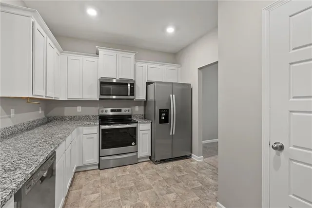 a kitchen with granite countertop a refrigerator and a sink