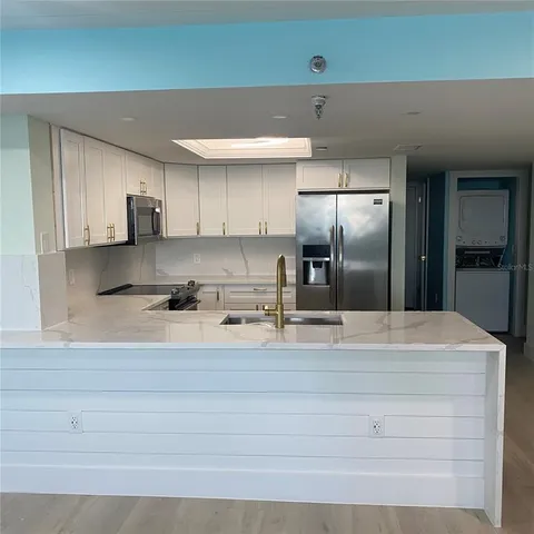 a kitchen with refrigerator and chairs