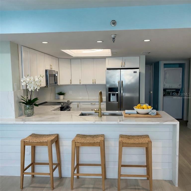 6035 Sea Ranch Drive, Unit 902 Hudson, FL 34667 - Photo 5 of 32 a kitchen with refrigerator and chairs