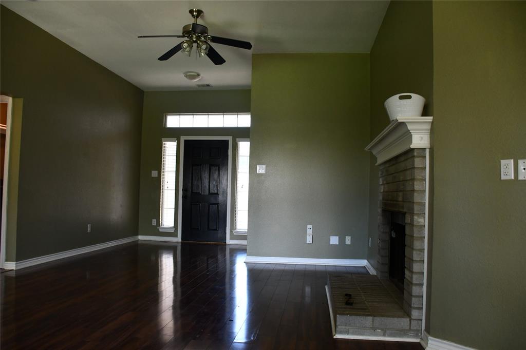 6241 Peach Tree Drive Midlothian, TX 76065 - Photo 4 of 19 Spacious interior featuring high ceilings, dark wood-finish flooring, a brick fireplace with a white mantel, and a dark paneled entry door with sidelight windows and transom