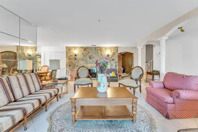 a living room with furniture potted plant and a large window