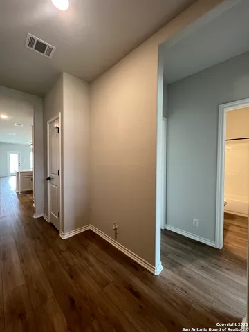 an empty room with wooden floor & windows